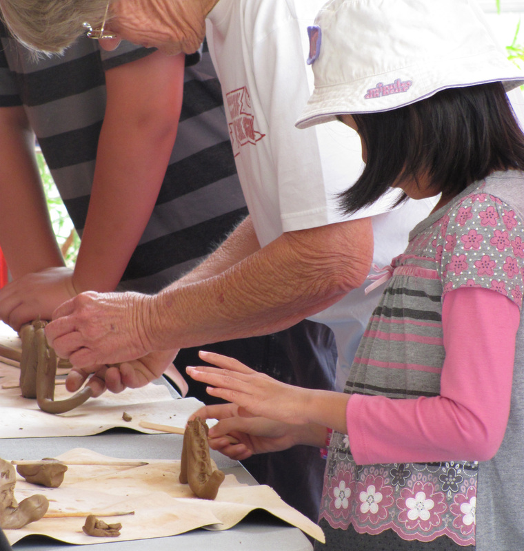 Adults and Children making pots out of clay